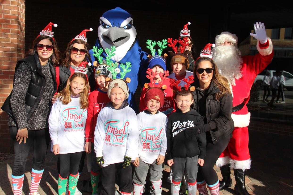 Participants pose for photos before the start of the 2022 Tinsel Trot on Saturday, Nov. 26 in Perry.