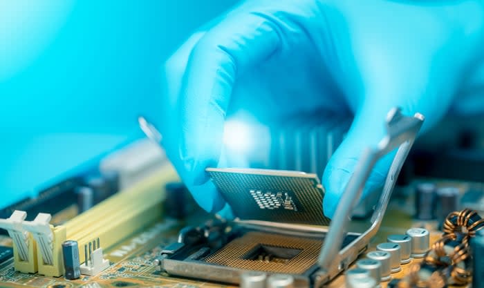 An engineer putting a chip onto a circuit board.