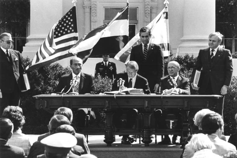 Egyptian president Anwar Sadat and Israeli prime minister Menachem Begin sign the Egypt–Israel Peace Treaty in Washington, DC, on March 26, 1979, with United States president Jimmy Carter acting as witness to the proceedings. UPI File Photo