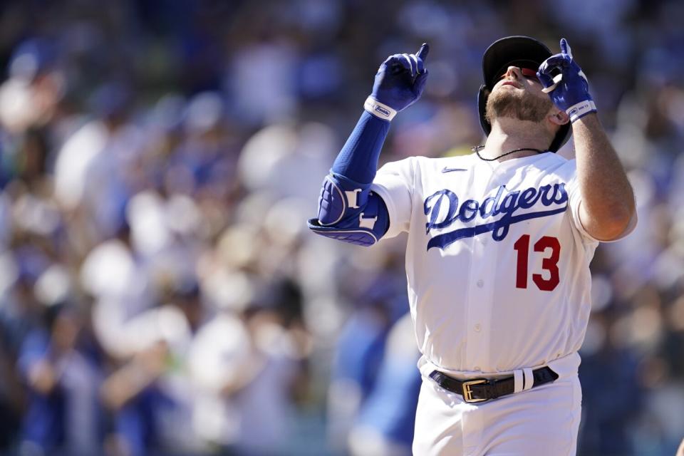 Los Angeles Dodgers' Max Muncy points skyward at home plate after his solo home run.