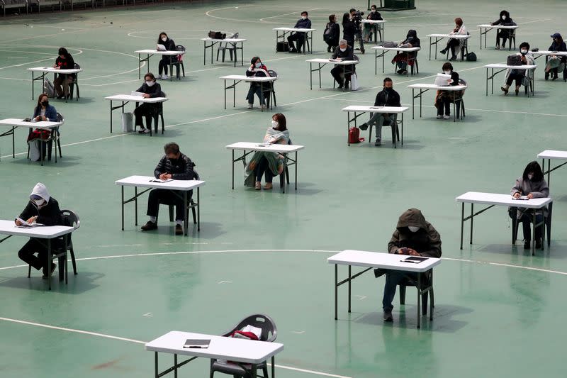 FILE PHOTO: South Korean job seekers take an exam outdoors amid social distancing measures to avoid the spread of the coronavirus disease (COVID-19) in Seoul