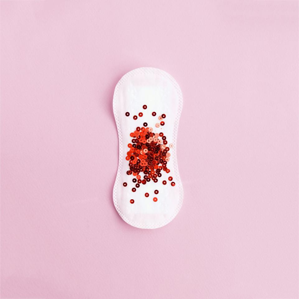 menstrual pad with red glitter on pastel background