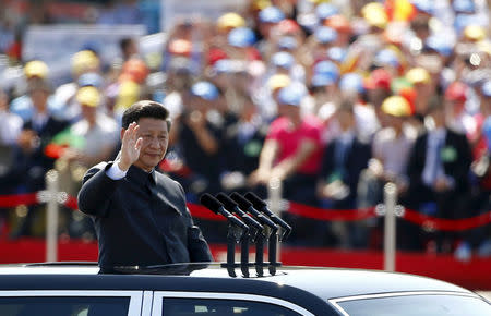 FILE PHOTO: Chinese President Xi Jinping waves as he reviews the army, at the beginning of the military parade marking the 70th anniversary of the end of World War Two, in Beijing, China, September 3, 2015. REUTERS/Damir Sagolj/File Photo