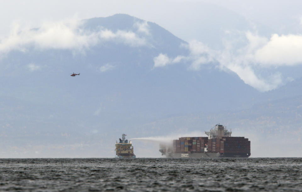 Ships work to control a fire onboard the MV Zim Kingston about eight kilometres from the shore in Victoria, B.C., on Sunday, October 24, 2021. The container ship caught fire on Saturday and 16 crew members were evacuated and brought to Ogden Point Pier. THE CANADIAN PRESS/Chad Hipolito/The Canadian Press via AP)