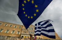 Protesters wave Greek and EU flags during a pro-Euro rally in front of the parliament building, in Athens, Greece, June 30, 2015. REUTERS/Yannis Behrakis