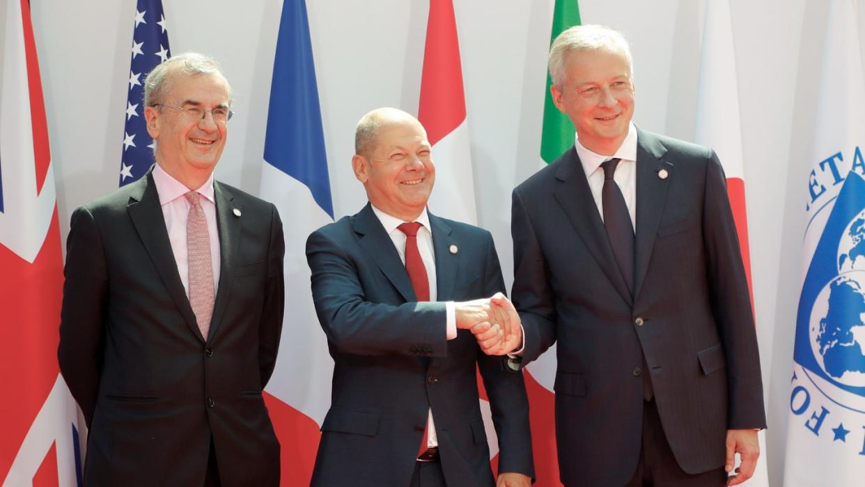 Bruno Le Maire (r-l), Finanzminister von Frankreich, begrüßt Olaf Scholz, Finanzminister von Deutschland, und Francois Villeroy de Galhau, Präsident der Banque de France, zu einem Treffen der G7-Finanzminister zur Vorbereitung auf den G7-Gipfel. Foto: Michel Euler/AP