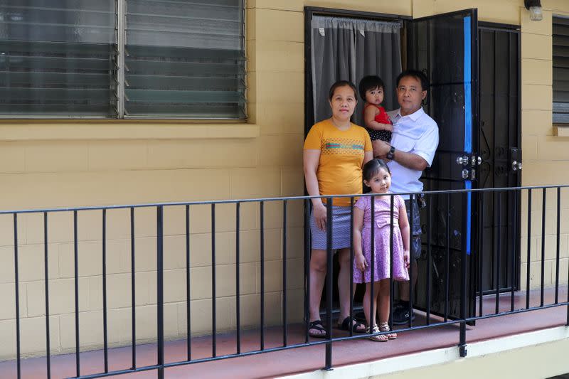 Judith and Jose Ramirez pose with their daughters outside their unit at an apartment complex in Honolulu