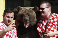 <p>Croatian football fans pose for a picture with a bear figure in a street during the 2018 FIFA World Cup. Vladimir Smirnov/TASS (Photo by Vladimir Smirnov\TASS via Getty Images) </p>