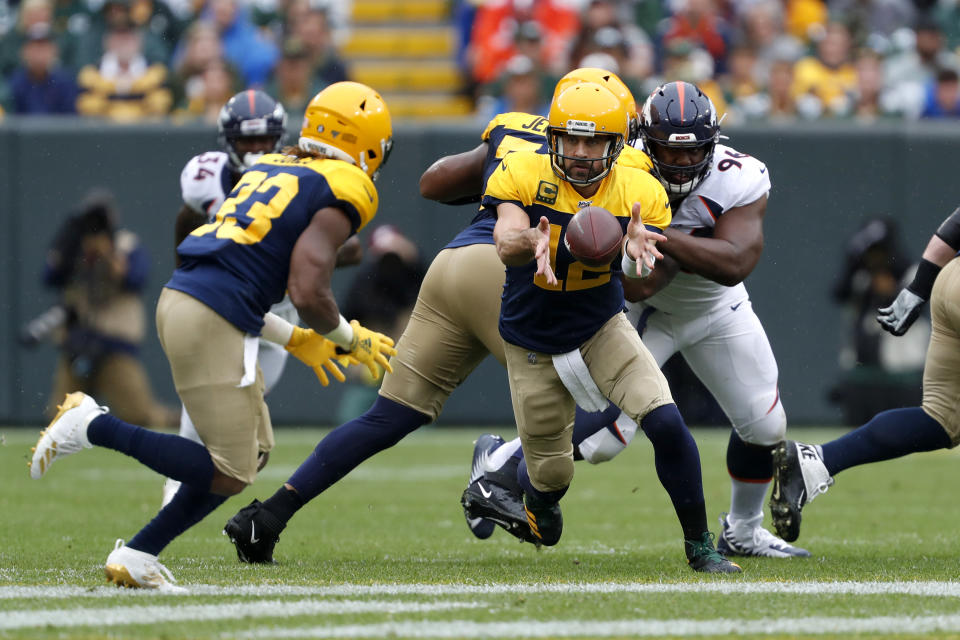 Green Bay Packers quarterback Aaron Rodgers, right, pitches the ball to running back Aaron Jones, left, during the first half of an NFL football game against the Denver Broncos Sunday, Sept. 22, 2019, in Green Bay, Wis. (AP Photo/Matt Ludtke)