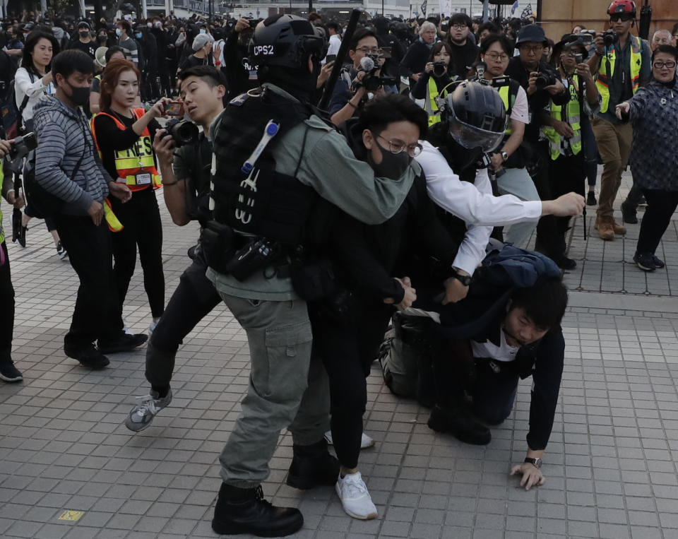 Riot policemen arrest protesters during a rally to show support for Uighurs and their fight for human rights in Hong Kong, Sunday, Dec. 22, 2019. (AP Photo/Lee Jin-man)