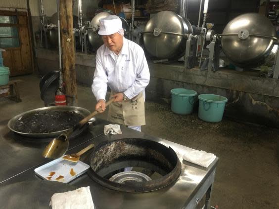 Katsuhiko Kurushima stirs a pan of seaweed in soy sauce (Tamara Hinson)