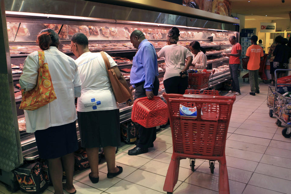 Zimbabwe buy various goods after some shops opened in Harare, Zimbabwe, Friday, Jan.18, 2019. Zimbabwe on Friday faced a "total internet shut down ", a media group said, after a days long violent crack down on people protesting a dramatic fuel price increase. (AP Photo/Tsvangirayi Mukwazhi)