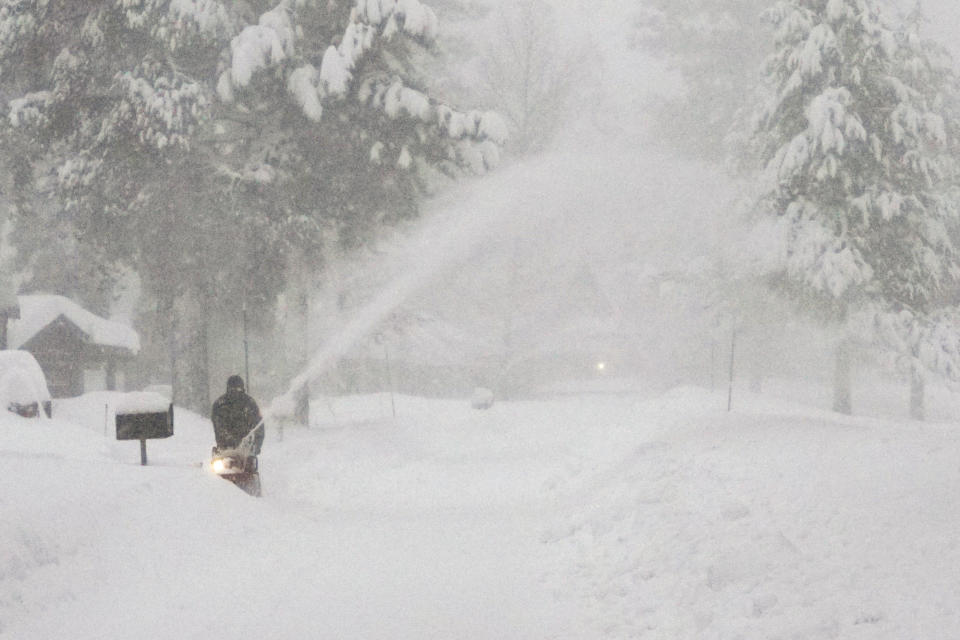 A person uses a snow blower to clear snow from a driveway during a storm, Saturday, March 2, 2024, in Truckee, Calif. A powerful blizzard howled Saturday in the Sierra Nevada as the biggest storm of the season shut down a long stretch of Interstate 80 in California and gusty winds and heavy rain hit lower elevations, leaving tens of thousands of homes without power. (AP Photo/Brooke Hess-Homeier)