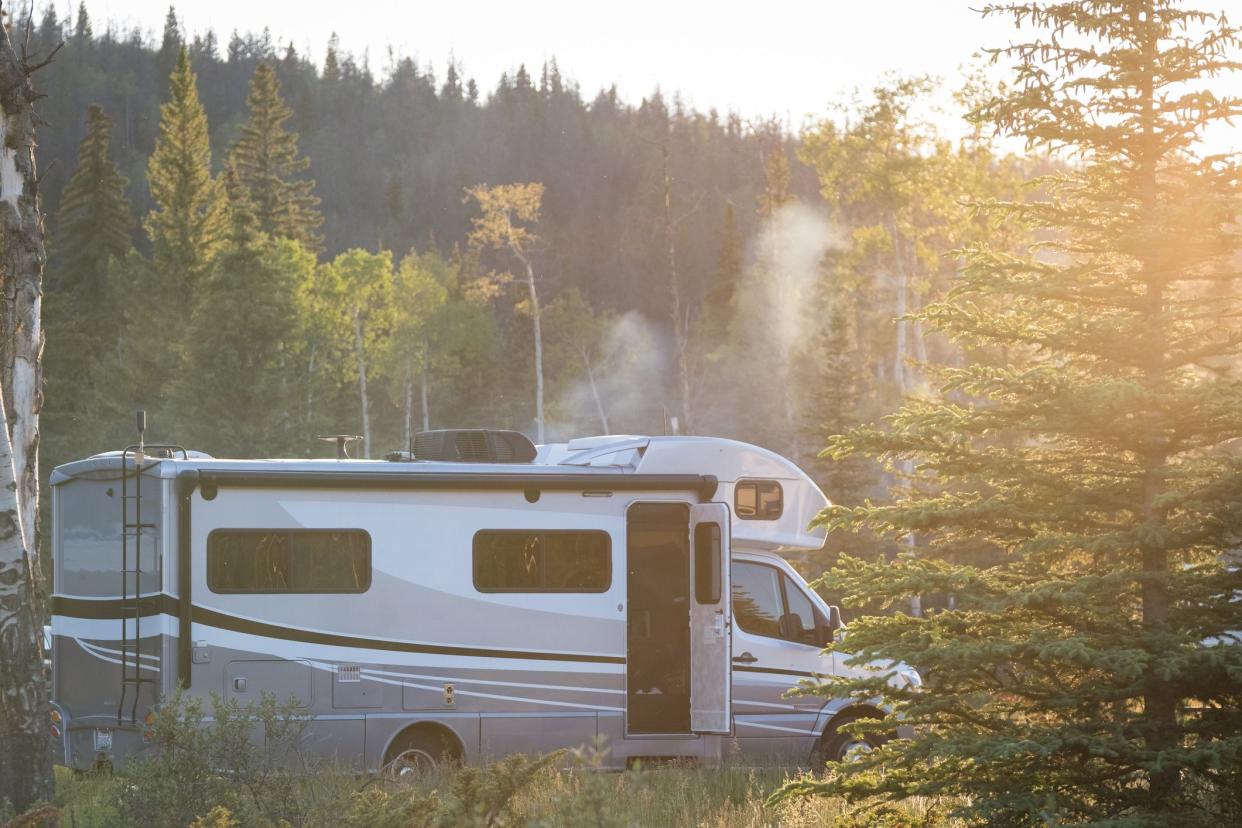 An empty campsite with a RV standing on it in the late afternoon sun. Campsites in and around the Banff National Park in Canada