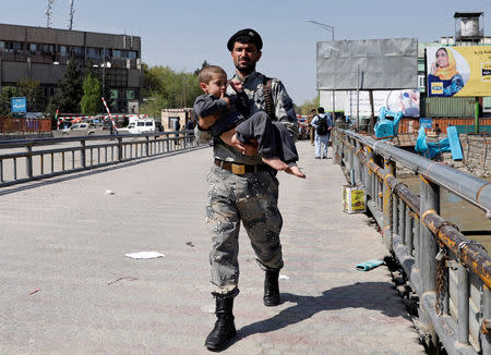 Foto del sábado de un soldado llevando a un niño rescatado del edificio del Ministerio de Comunicaciones de Kabul que fue atacado por militantes. Abr 20, 2019. REUTERS/Mohammad Ismail