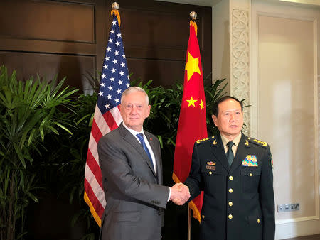 FILE PHOTO: U.S. Defense Secretary Jim Mattis and China's Defense Minister Wei Fenghe greet each other ahead of talks in Singapore, October 18, 2018. REUTERS/Phil Stewart/File Photo