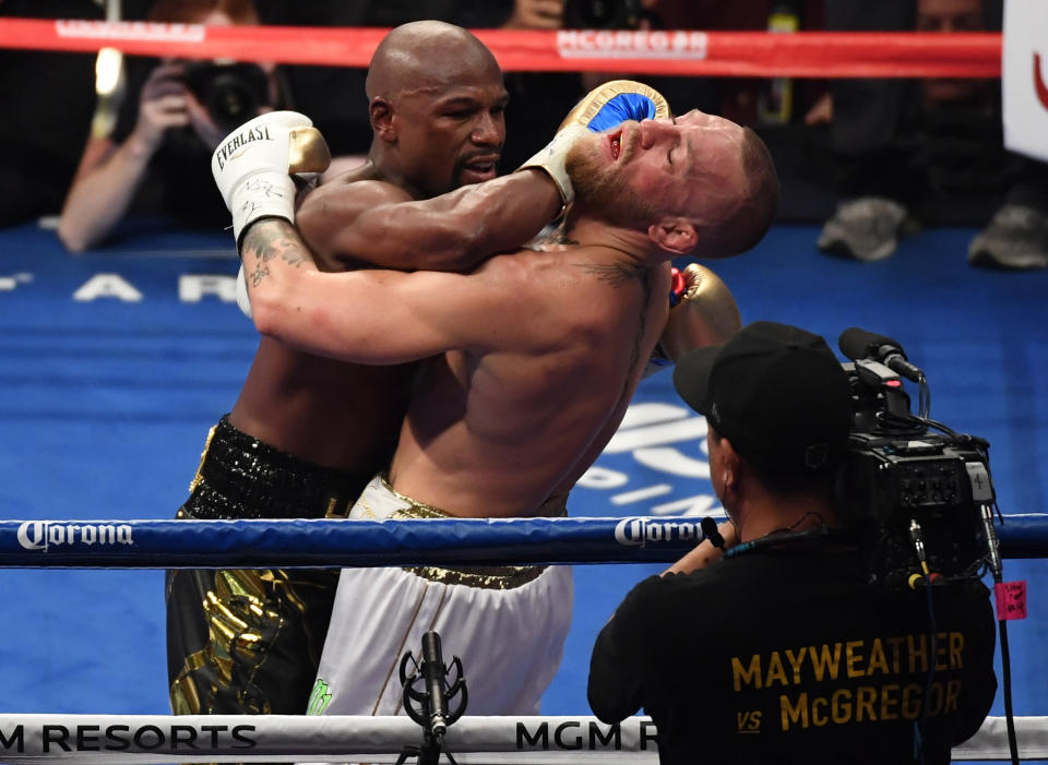 <p>(L-R) Floyd Mayweather Jr. throws a punch at Conor McGregor during their super welterweight boxing match on August 26, 2017 at T-Mobile Arena in Las Vegas, Nevada. </p>