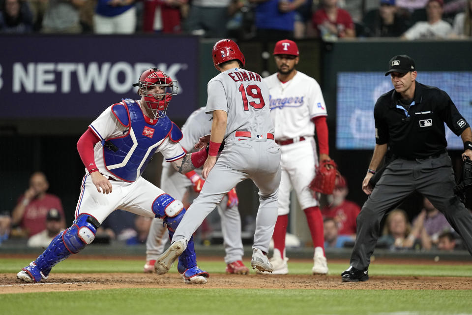Texas Rangers catcher Jonah Heim, left, tags out St. Louis Cardinals' Tommy Edman (19) who was trying to score on a Nolan Arenado double in the eighth inning of a baseball game, Monday, June 5, 2023, in Arlington, Texas. (AP Photo/Tony Gutierrez)