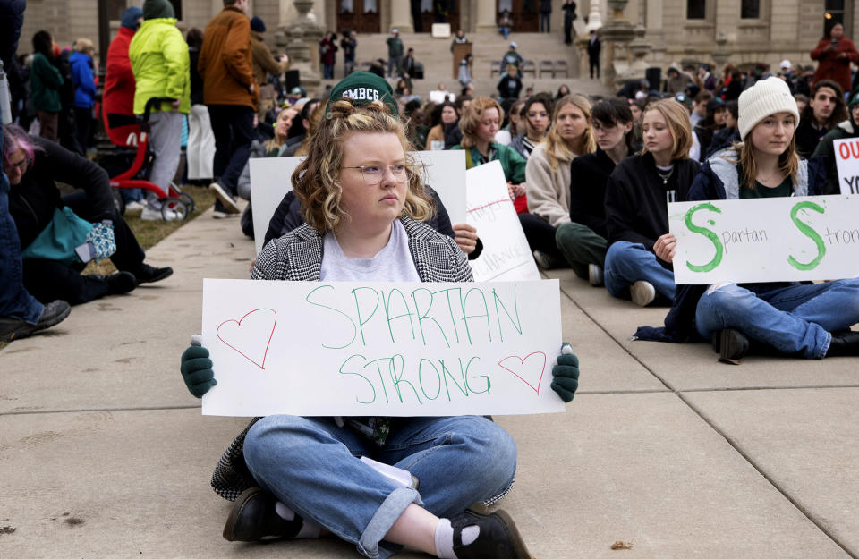 Demonstrators hold signs to protest gun violence at a student sit-in at the Michigan Capitol building following Monday's mass shooting at Michigan State University, Wednesday, Feb. 15, 2023, in Lansing, Mich. (Brice Tucker/The Flint Journal via AP)