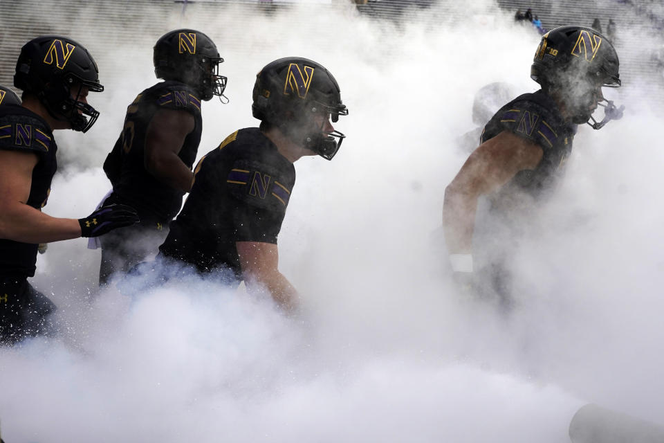 Northwestern players run to the field before an NCAA college football game against Maryland, Saturday, Oct. 28, 2023, in Evanston, Ill. (AP Photo/Nam Y. Huh)