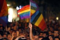 A man waves a rainbow flag as thousands of Israelis from the gay community and supporters gather in downtown Jerusalem on August 1, 2015