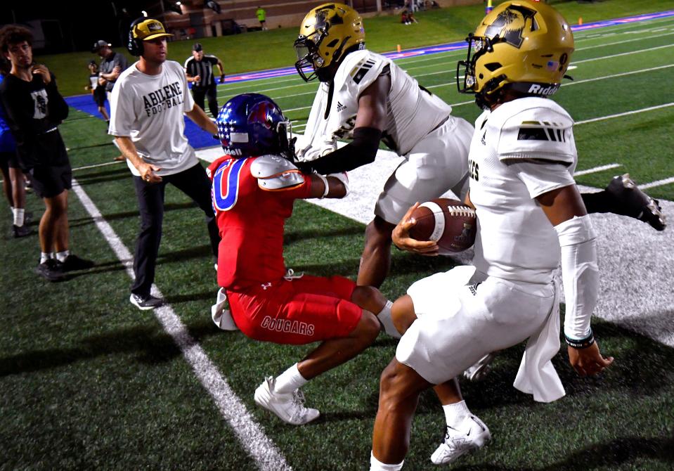 Cooper High defensive back Jeremiah Appel drags Abilene High wide receiver Ryland Bradford out of bounds as Eagles quarterback Brayden Henry follows during Friday’s crosstown showdown football game at Shotwell Stadium. Final score was 26-7, Abilene High.