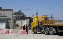 Hamas security officers check an empty truck entering Israel at the Kerem Shalom cargo crossing with Israel, in Rafah, southern Gaza Strip, Monday, June 21, 2021. Israel on Monday eased some restrictions on the Gaza Strip that have threatened a fragile cease-fire which halted an 11-day war last month with the territory's Hamas rulers, Palestinian officials said. (AP Photo/Adel Hana)