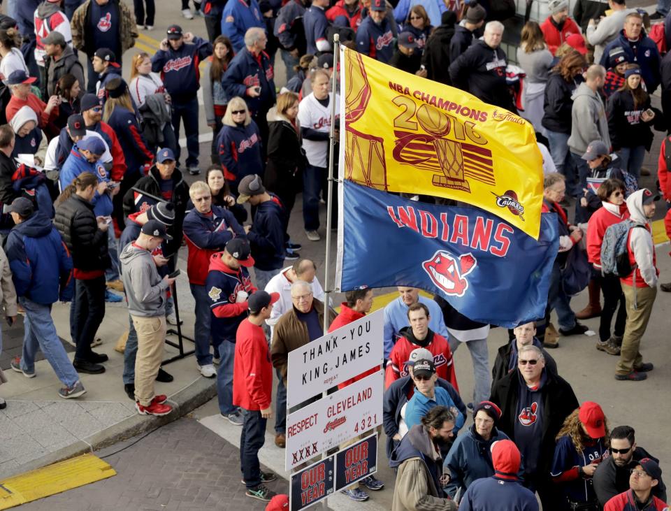 A Cavs championship flag flies above an Indians flag as fans prepare for Cleveland's biggest sports night. (AP)