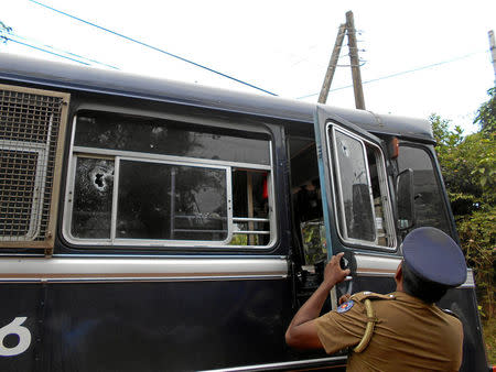 A Sri Lanka's police officer inspects the prison bus after gunmen opened fire in Colombo, Sri Lanka February 27, 2017. REUTERS/Stringer