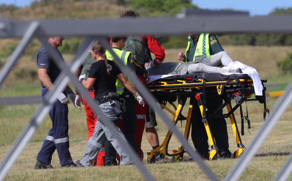 Emergency services attend to an injured person arriving at the Whakatane Airfield after the volcanic eruption (Picture: AP)