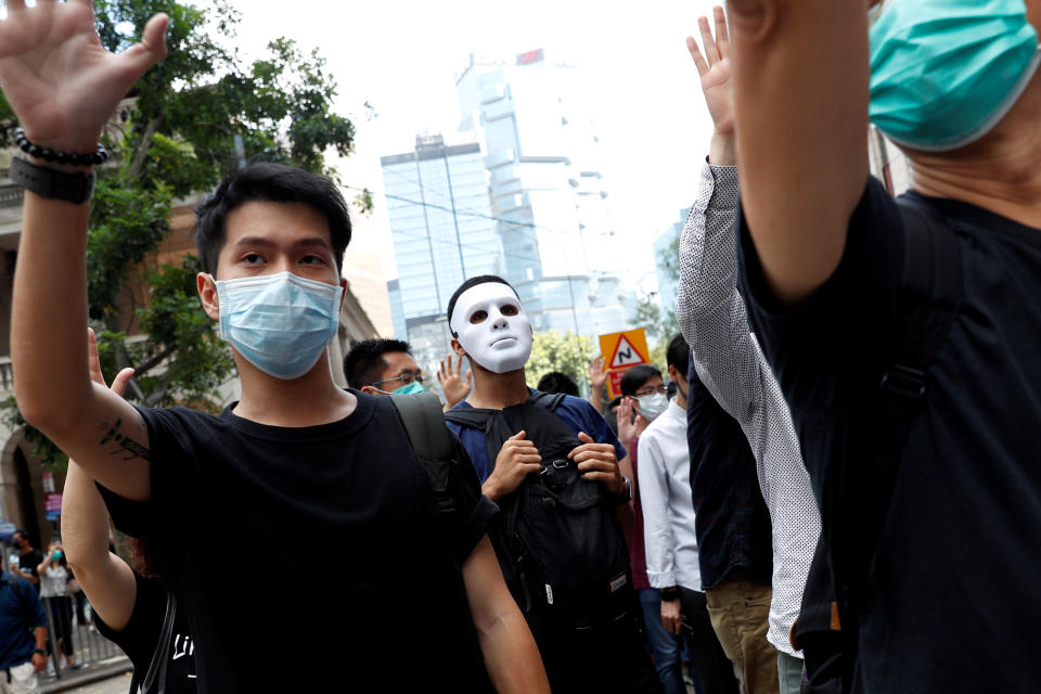 Anti-government office workers wearing masks attend a lunch time protest, after local media reported on an expected ban on face masks under emergency law, at Central, in Hong Kong, China, October 4, 2019. REUTERS/Tyrone Siu