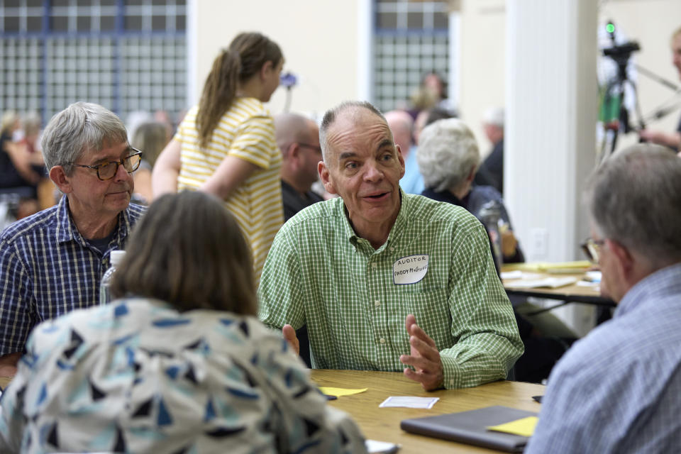 Democrat Paddy McGuire, incumbent Mason County auditor, center right, talks with voters during before a "candidate speed-dating" style forum, Thursday, Oct. 13, 2022, in Shelton, Wash. (AP Photo/John Froschauer)