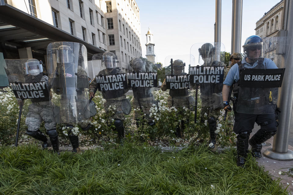 FILE - In this June 1, 2020, file photo District of Columbia National Guard, and U.S. Park Police, advance through the white roses in front of the AFL-CIO headquarters, with St. John's Church behind them, as they move demonstrators back after they gathered to protest the death of George Floyd near the White House in Washington. Floyd died after being restrained by Minneapolis police officers. (AP Photo/Alex Brandon, File)