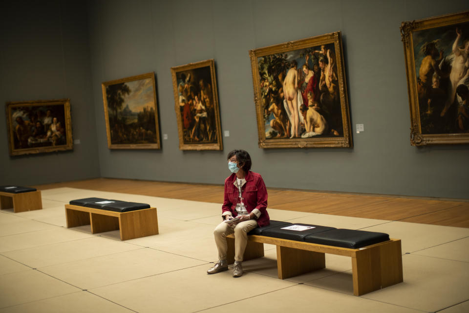 FILE - In this Tuesday, May 19, 2020 file photo, a woman wears a face mask, to prevent against the spread of coronavirus, at the Royal Museum of Fine Arts in Brussels, Tuesday, May 19, 2020. Wearing a face mask will become mandatory from Saturday, July 11, 2020 in Belgian shops, cinemas, entertainment venues and other indoor spaces. The Belgian government said the decision was made following a meeting of politicians and experts in charge of the lockdown exit strategy who decided to follow recommendations issued by the health ministry's scientific advisory body. (AP Photo/Francisco Seco, File)