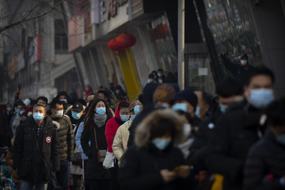 People wearing face masks to protect against the spread of the coronavirus line up for mass COVID-19 testing in a central district of Beijing, Friday, Jan. 22, 2021. Beijing has ordered fresh rounds of coronavirus testing for about 2 million people in the downtown area following new cases in the Chinese capital. (AP Photo/Mark Schiefelbein)