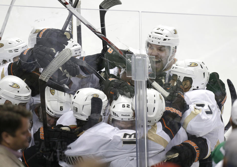 Anaheim Ducks Nick Bonino (13) is mobbed by his teammates after he scored the game winning goal in overtime of Game 6 to win the first-round NHL hockey playoff series against the Dallas Stars in Dallas, Sunday, April 27, 2014. The final score 5-4 for the Ducks. (AP Photo/LM Otero)