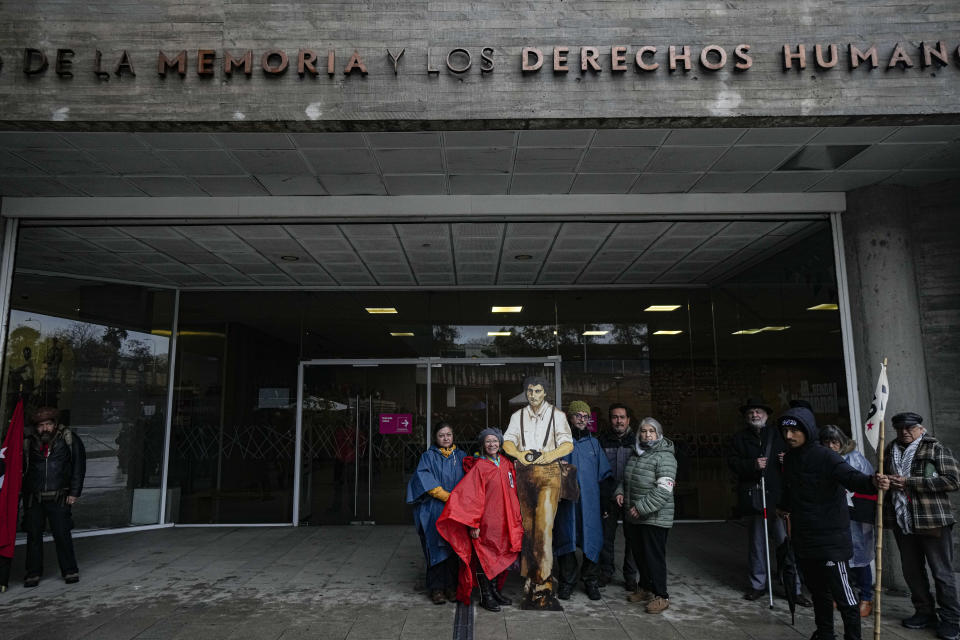 Un familiar lleva un recorte de cartón que representa al fotógrafo Teobaldo Tello, antes de una marcha que conmemora la llamada "Operación Colombo", en la que más de 100 disidentes, incluido Tello, fueron ejecutados por las fuerzas de seguridad de la dictadura del general Augusto Pinochet en Santiago, Chile, el sábado 22 de julio de 2023. (AP Foto/Esteban Felix)