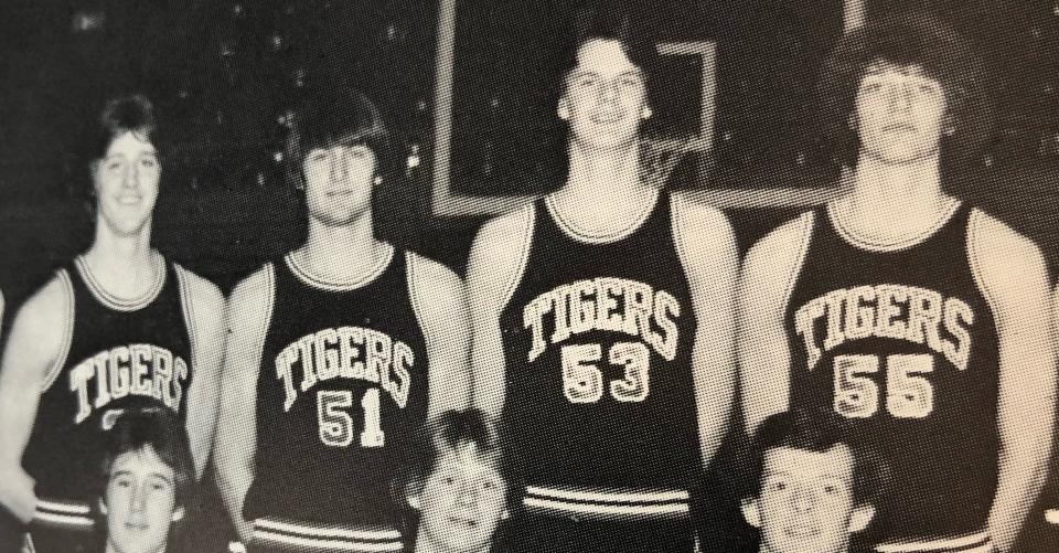 The 7-foot Mike Shanks (53) is pictured with 6-5 Mike Busch (left0, 6-5 Ken Konst (51) and 6-9 Craig Dudley on the team picture for Huron High School's 1980-81 boys basketball team.