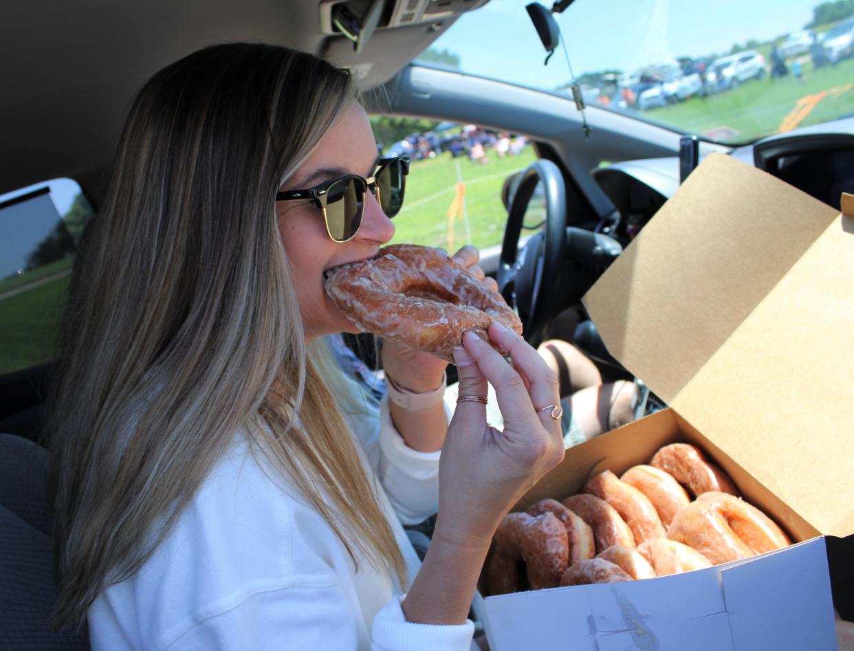 A fan bites into a Mrs. Yoder's Kitchen sourdough donut.