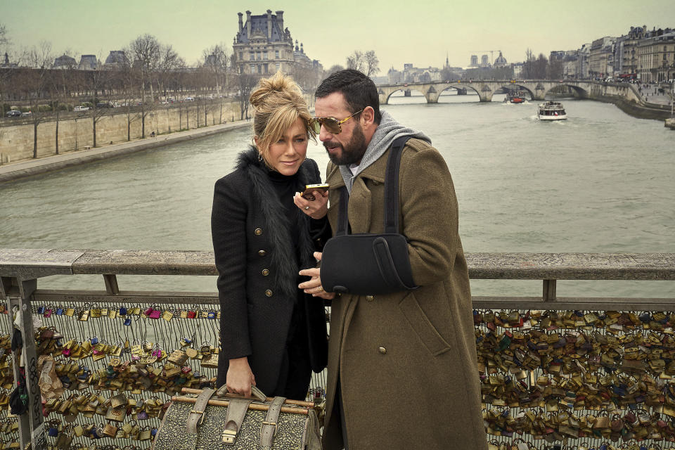 This image released by Netflix shows Jennifer Aniston, left, and Adam Sandler in a scene from the film "Murder Mystery 2." (Scott Yamano/Netflix via AP)