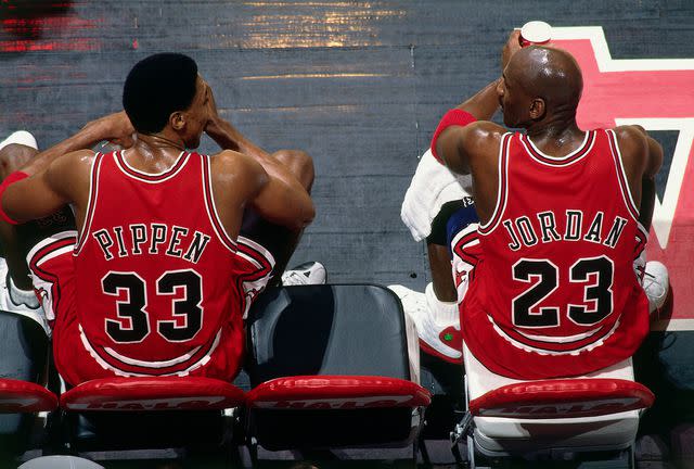 <p>Andy Hayt/NBAE/Getty</p> Scottie Pippen #33 and Michael Jordan #23 of the Chicago Bulls sit on the bench during the game against the Vancouver Grizzlies on Jan. 27, 1998