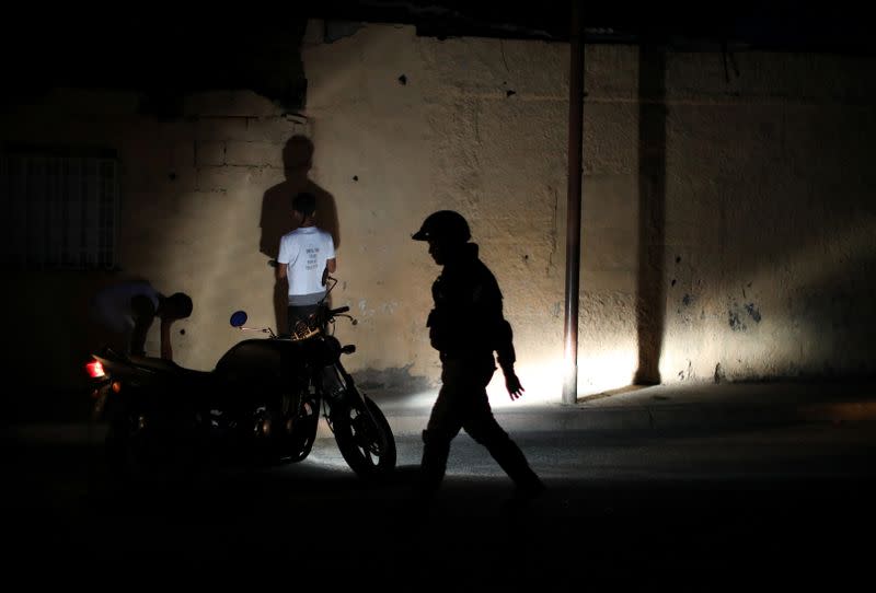 Members of the Special Action Force of the Venezuelan National Police (FAES) stop people during a night patrol, in Barquisimeto