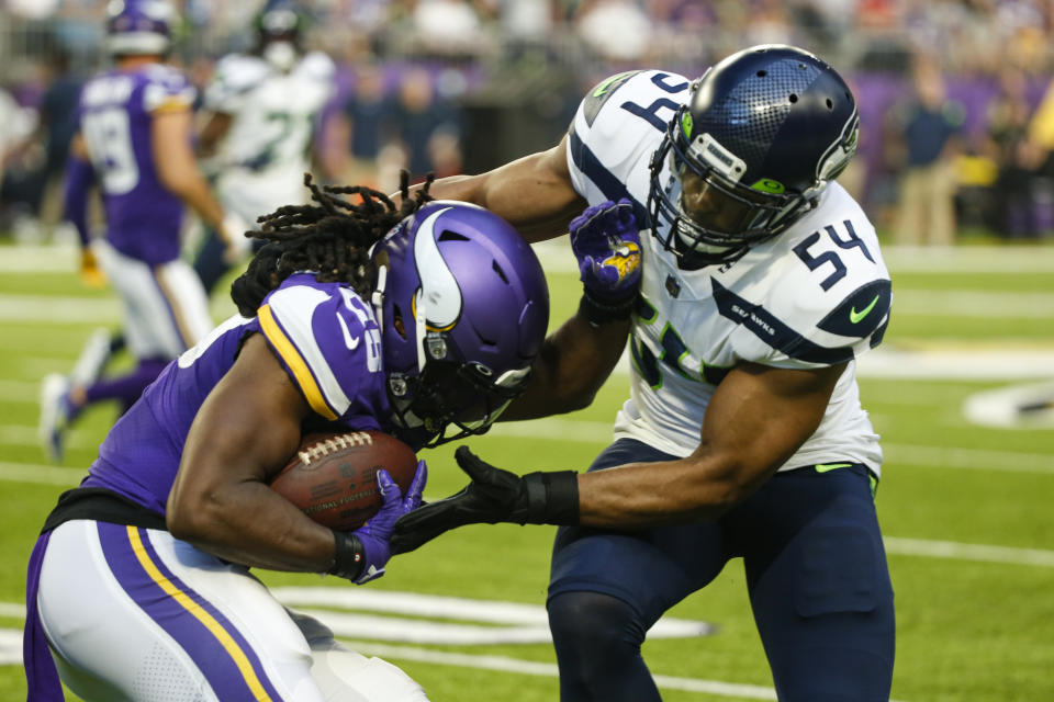 Seattle Seahawks middle linebacker Bobby Wagner (54) tackles Minnesota Vikings running back Alexander Mattison (25) in the first half of an NFL football game in Minneapolis, Sunday, Sept. 26, 2021. (AP Photo/Bruce Kluckhohn)