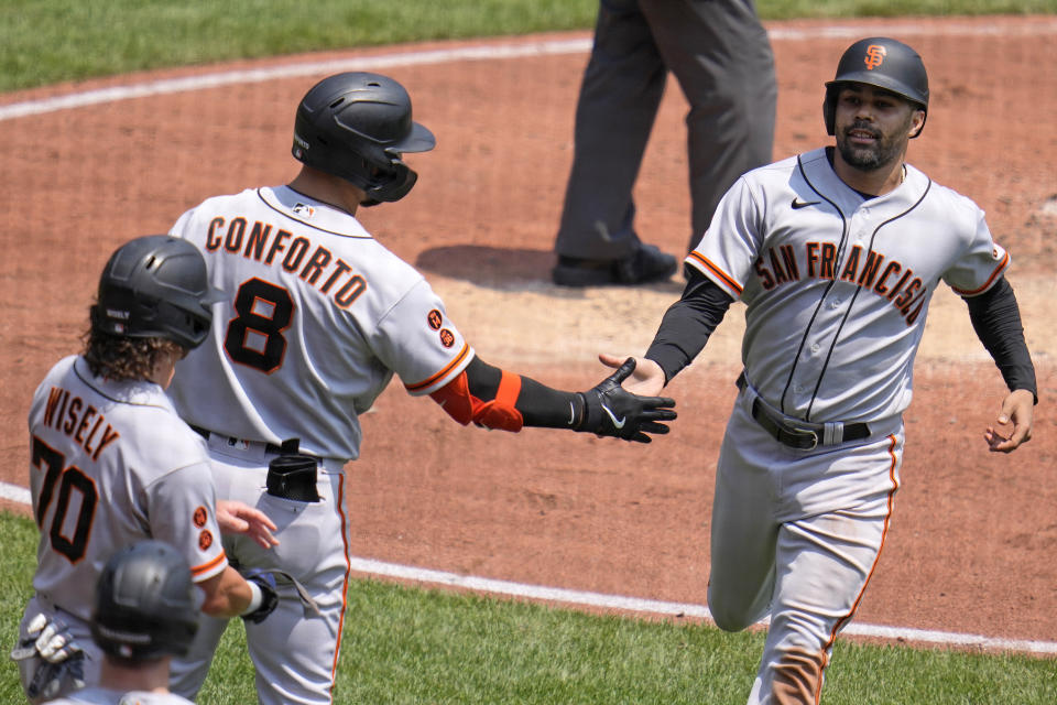 San Francisco Giants' LaMonte Wade Jr., right, is greeted by Michael Conforto (8) after scoring the second of two runs on a single by J.D. Davis off Pittsburgh Pirates starting pitcher Osvaldo Bido during the third inning of a baseball game in Pittsburgh, Sunday, July 16, 2023. (AP Photo/Gene J. Puskar)