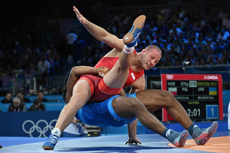 El polaco Arkadiusz Marcin Kulynycz (rojo) se enfrenta con el ucraniano Zhan Beleniuk (azul) por el torneo de lucha grecorromana masculina de 87 kg por la medalla de bronce en el Champ-de-Mars Arena 