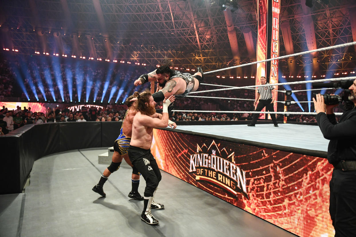 JEDDAH, SAUDI ARABIA - MAY 25: Bronson Reed flying through the ropes against Sami Zayn and Chad Gable during King and Queen of the Ring at Jeddah Superdome on May 25, 2024 in Jeddah, Saudi Arabia.  (Photo by WWE/Getty Images)