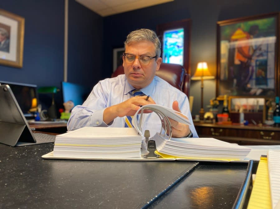 Patrick McLaughlin thumbs through a binder filled with discovery motions filed in the state-level civil cases filed against SLED, the Attorney General, and the SC Department of Agriculture. McLaughlin said he filed the motions in an attempt to force SLED to turn over documentation related to its handling of the allegations against Pendarvis and the raid of his family farm in September 2019. (WJZY Photo/Jody Barr)