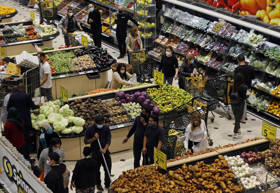 People shop at a supermarket as they stock up on provisions, in Beirut, Lebanon, Monday, Jan. 11, 2021. Panic buyers swarmed supermarkets after reports the government planned to also order them shut in the tightened lockdown. Long lines formed outside chain supermarkets, sparking fear the crowds could further spread the virus. (AP Photo/Bilal Hussein)