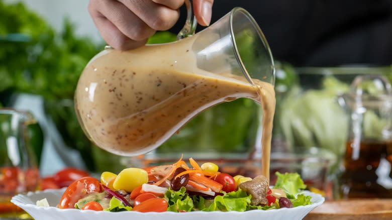 Pouring dressing over salad