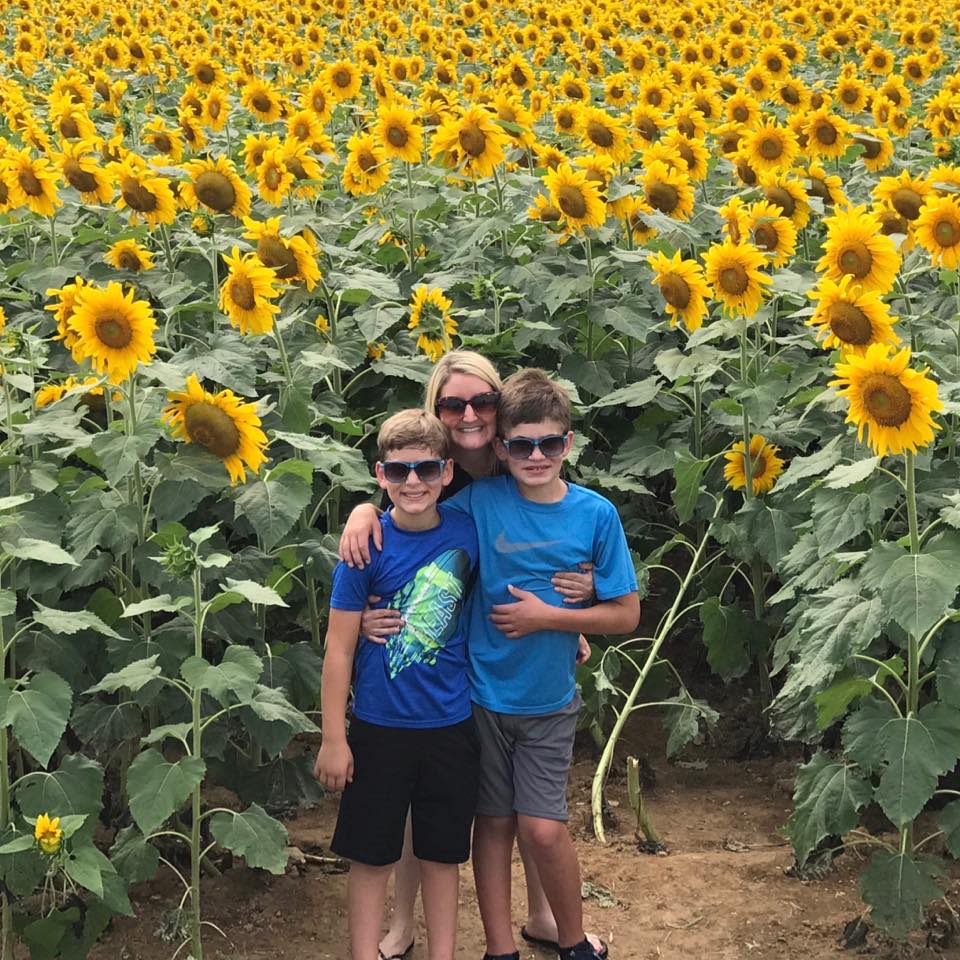 Connor Dobbyn is seen with his mum and brother in a sunflower field. 